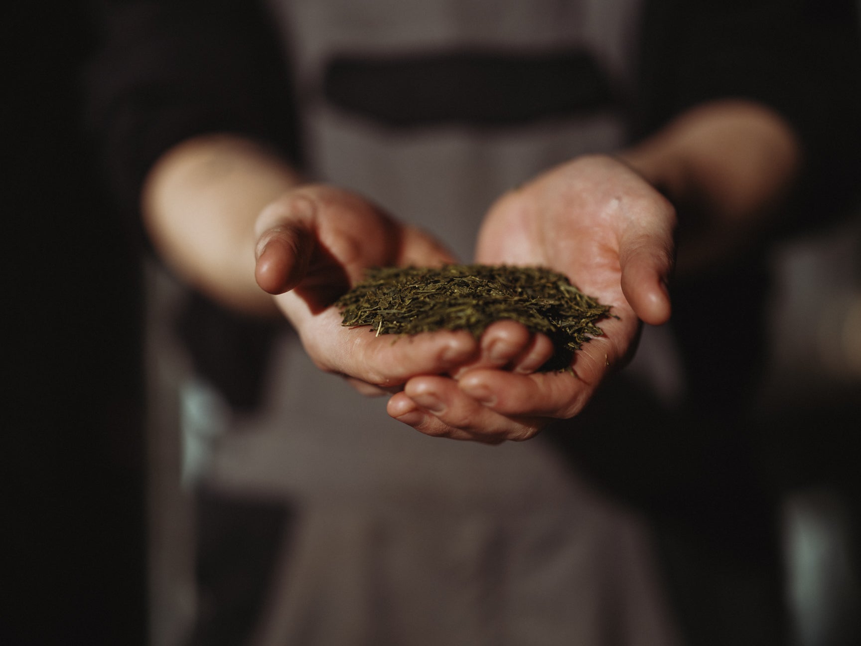 Does kombucha contain caffeine? It depends. | Man holding a small glass brewing jar