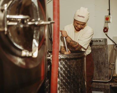 Is kombucha alcoholic? How much does it contain? | The brewing process, lady stirring a large mixing vessel