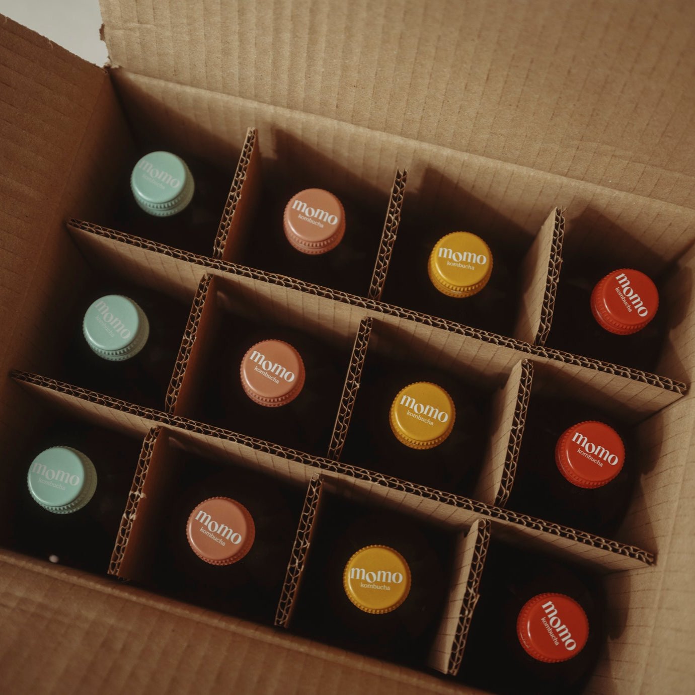 Selection of 12 Momo Kombucha bottles in packaging - ready to go to a customer.